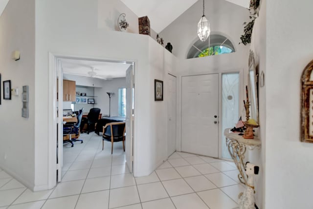 foyer entrance with high vaulted ceiling and light tile patterned floors