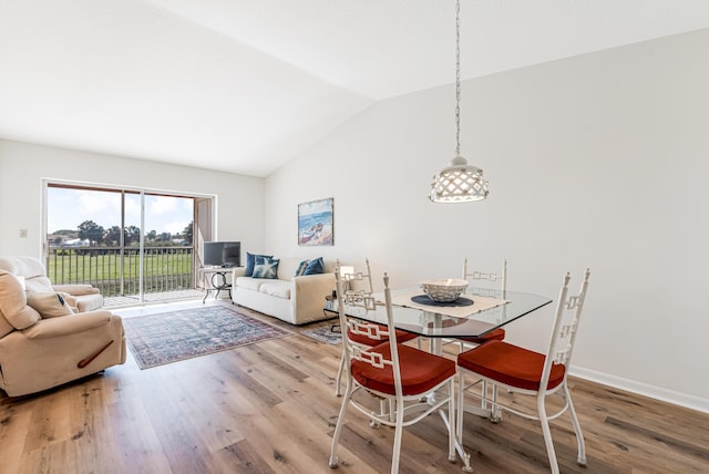 dining area with vaulted ceiling and hardwood / wood-style floors