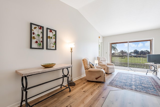 living area featuring lofted ceiling and light hardwood / wood-style floors