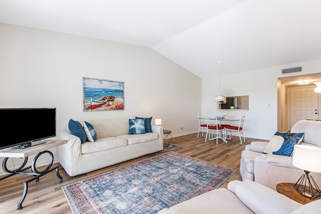 living room with lofted ceiling and light hardwood / wood-style flooring