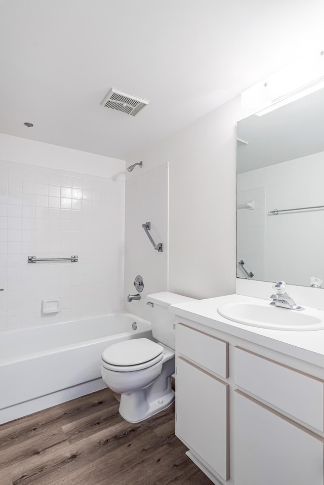 full bathroom featuring wood-type flooring, toilet, vanity, and tiled shower / bath