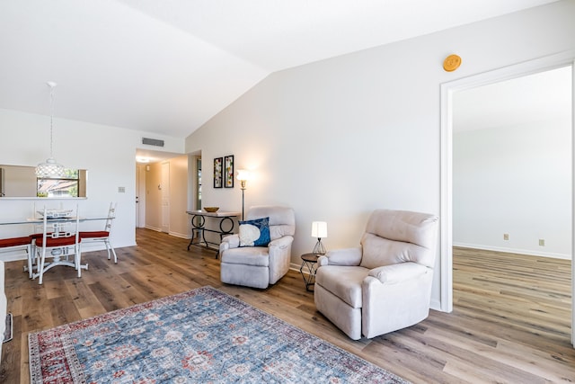 living area featuring vaulted ceiling and light wood-type flooring