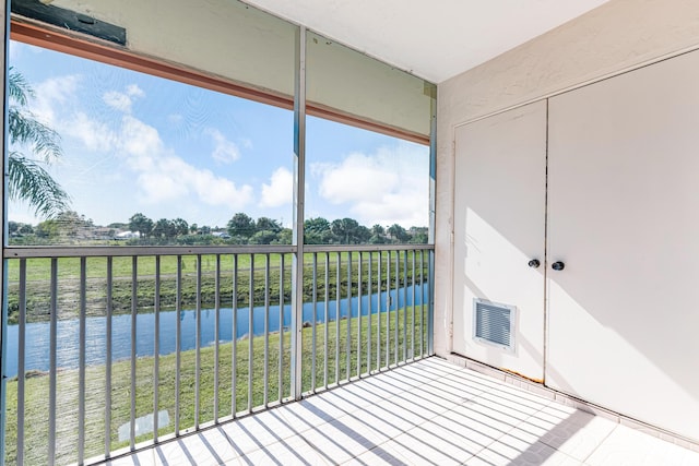 unfurnished sunroom featuring a water view