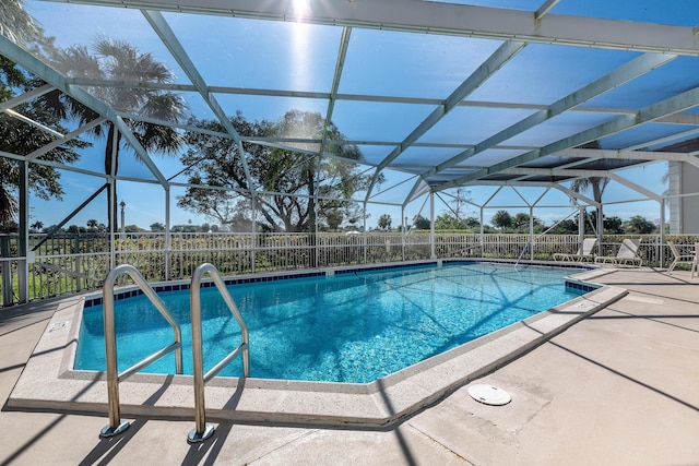 view of swimming pool with a patio area and glass enclosure