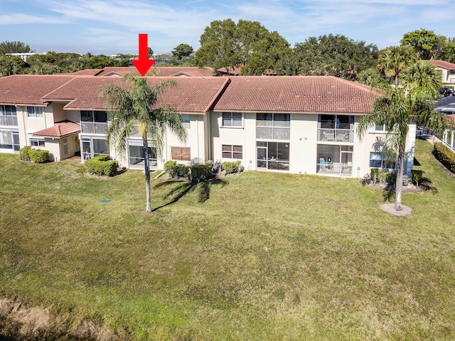 rear view of property featuring a lawn