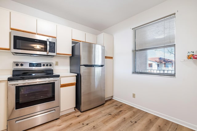 kitchen with white cabinetry, stainless steel appliances, and light hardwood / wood-style floors