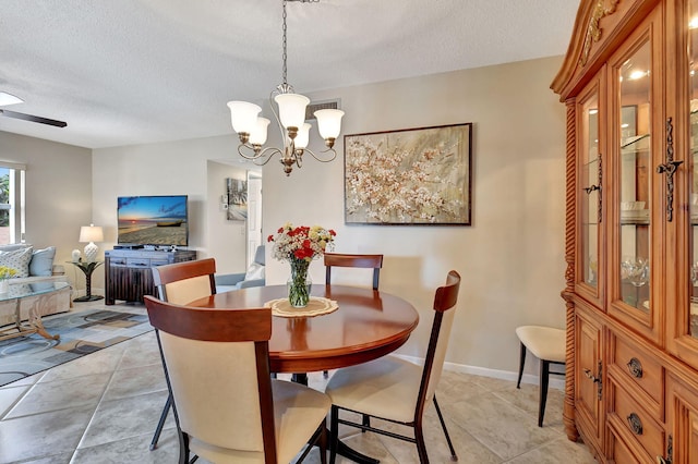 dining room with light tile patterned floors, ceiling fan with notable chandelier, and a textured ceiling