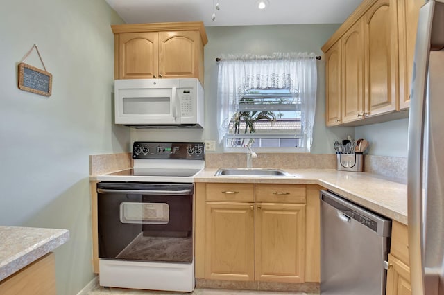 kitchen with appliances with stainless steel finishes, sink, and light brown cabinets