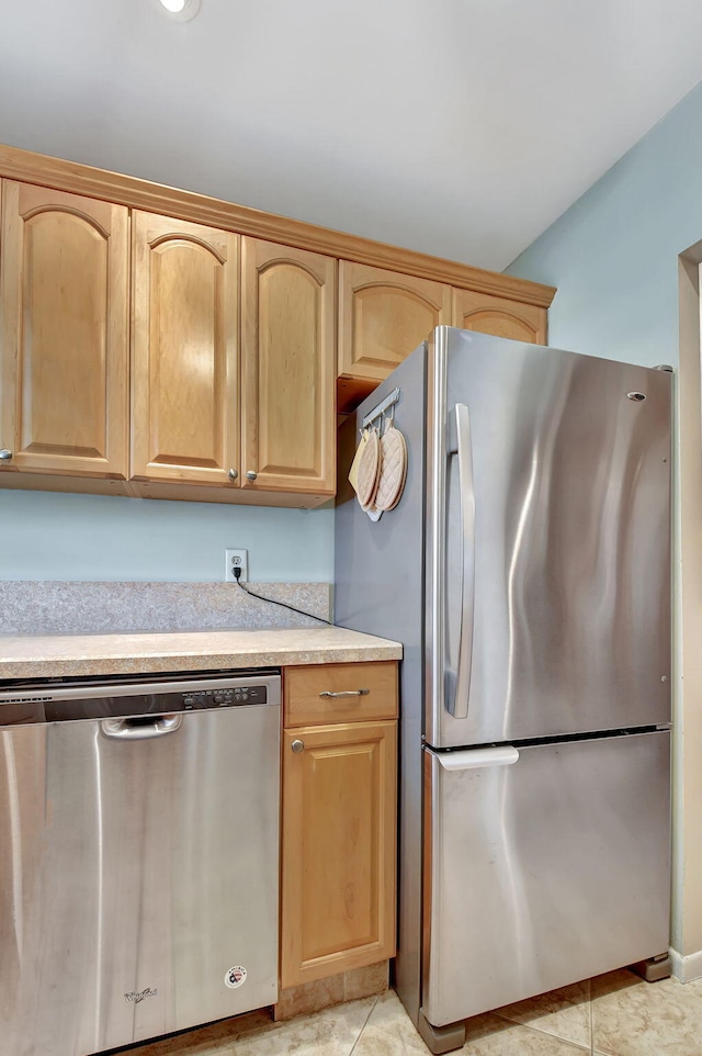 kitchen featuring light tile patterned floors, stainless steel appliances, and light brown cabinets