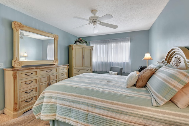 bedroom featuring ceiling fan, light carpet, and a textured ceiling