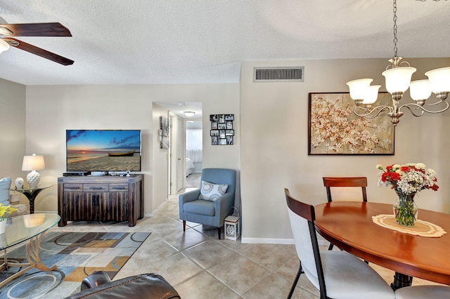 dining room with light tile patterned floors, ceiling fan with notable chandelier, and a textured ceiling