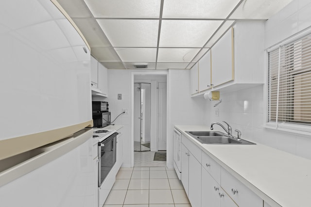 kitchen with sink, a drop ceiling, white cabinets, and white appliances