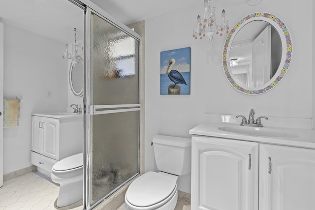 bathroom featuring vanity, an enclosed shower, an inviting chandelier, and toilet