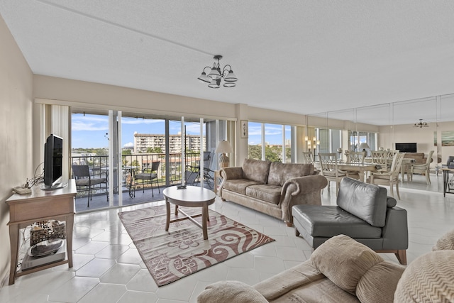 living room featuring a wealth of natural light, a textured ceiling, a chandelier, and light tile patterned floors