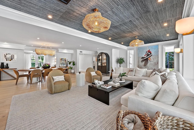 living room featuring ornamental molding, a wealth of natural light, and light hardwood / wood-style floors