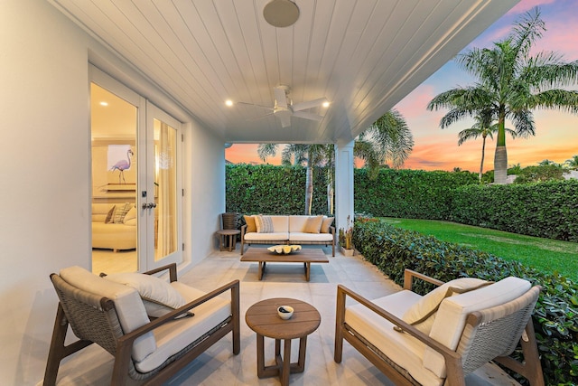 patio terrace at dusk featuring ceiling fan and an outdoor hangout area