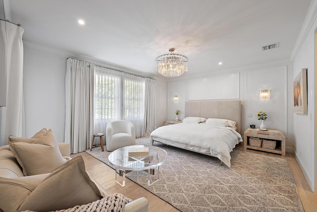 bedroom with hardwood / wood-style floors, a notable chandelier, and ornamental molding