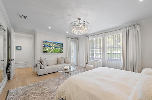 bedroom with a notable chandelier, light hardwood / wood-style flooring, and ornamental molding