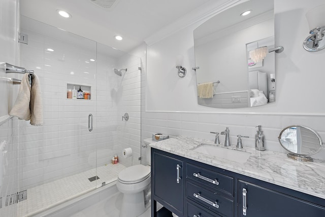 bathroom with vanity, toilet, an enclosed shower, and tile walls