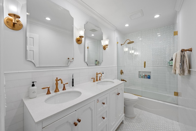 full bathroom with bath / shower combo with glass door, tile walls, vanity, and crown molding