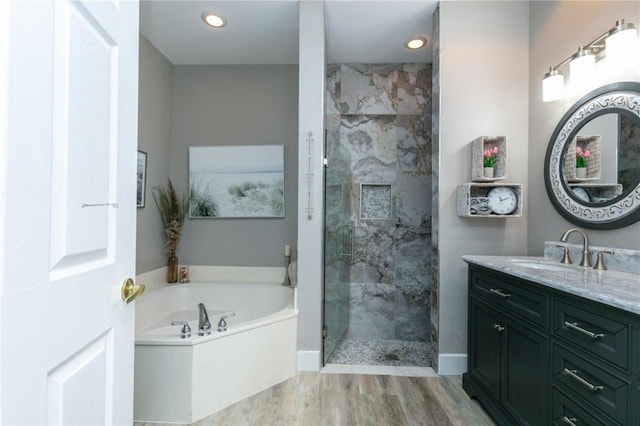 bathroom featuring vanity, separate shower and tub, and wood-type flooring