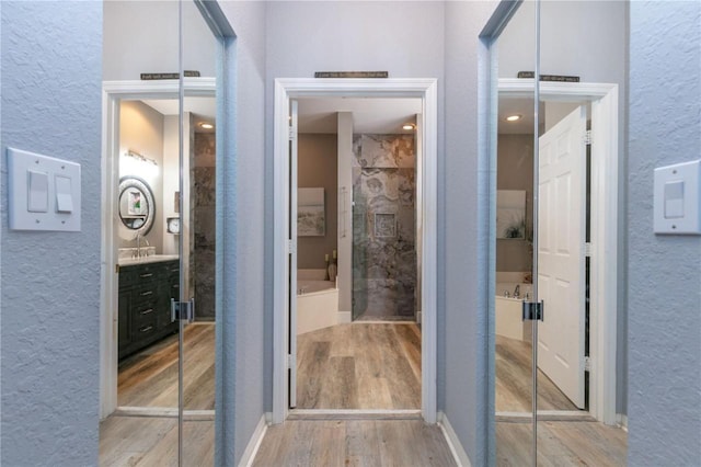 bathroom with a shower with door, vanity, and hardwood / wood-style floors