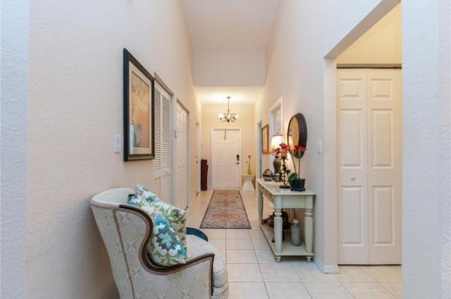 corridor with an inviting chandelier and light tile patterned floors