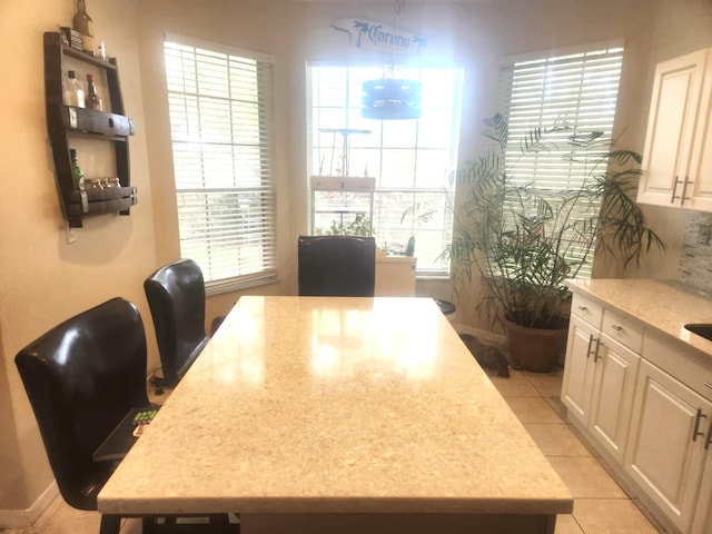 dining area with a wealth of natural light and light tile patterned floors