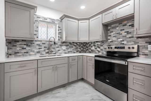 kitchen with gray cabinets, stainless steel electric stove, sink, and tasteful backsplash