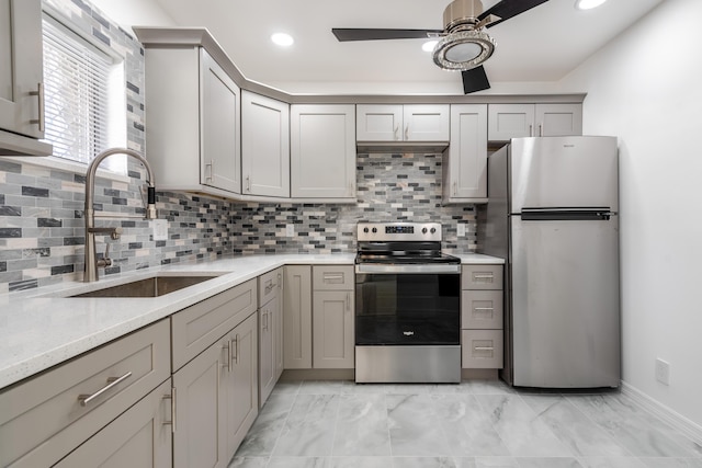 kitchen featuring appliances with stainless steel finishes, sink, gray cabinetry, and backsplash