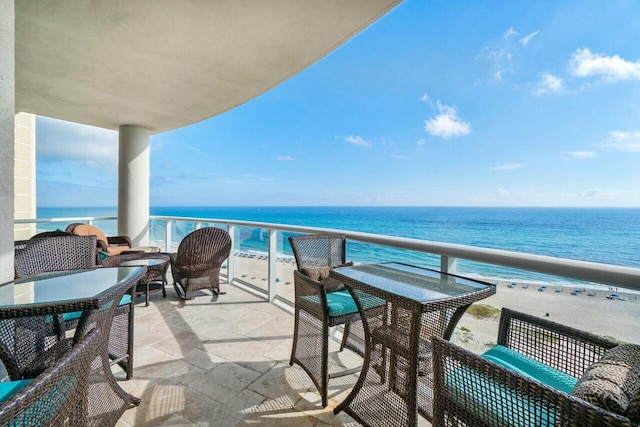 balcony featuring a water view and a beach view