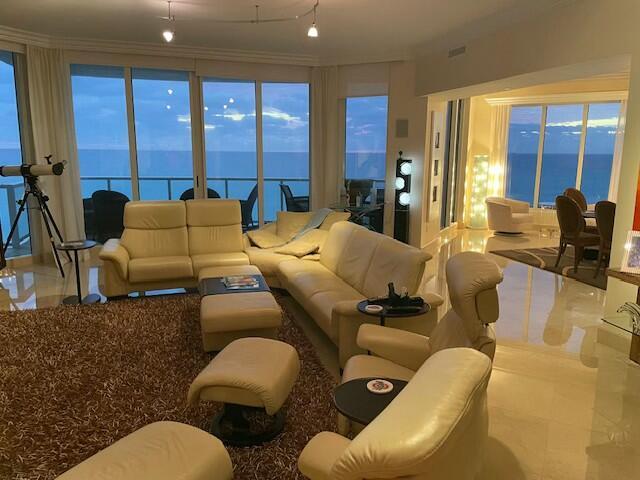 living room featuring ornamental molding and a water view