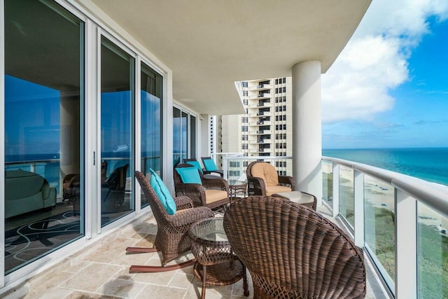 balcony featuring a water view and a view of the beach