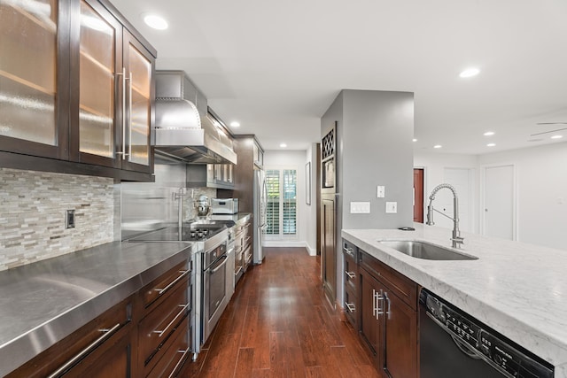 kitchen featuring appliances with stainless steel finishes, range hood, tasteful backsplash, sink, and dark hardwood / wood-style flooring