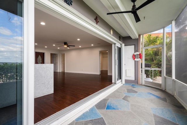 unfurnished sunroom featuring ceiling fan