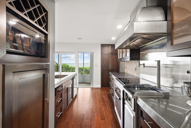 laundry area featuring stacked washer / drying machine and dark hardwood / wood-style floors