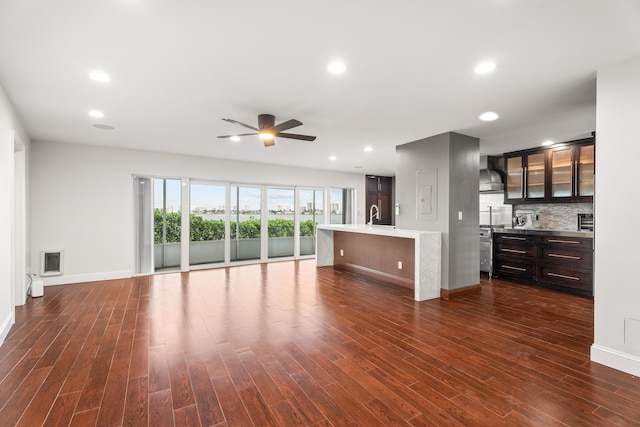 unfurnished living room featuring sink, dark wood-type flooring, and ceiling fan