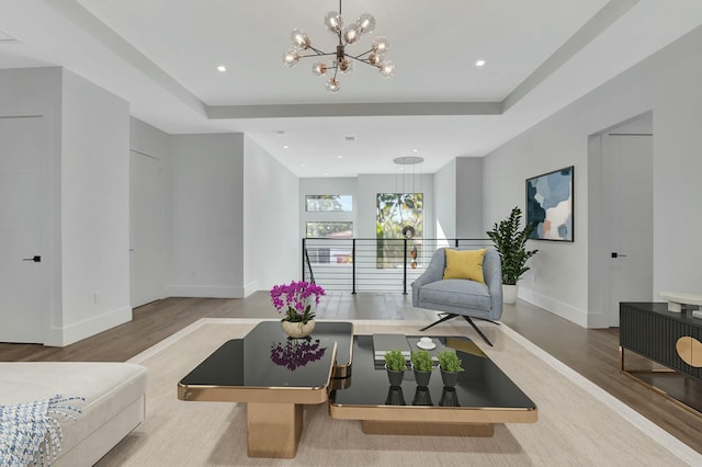 interior space with hardwood / wood-style flooring, a notable chandelier, and a tray ceiling