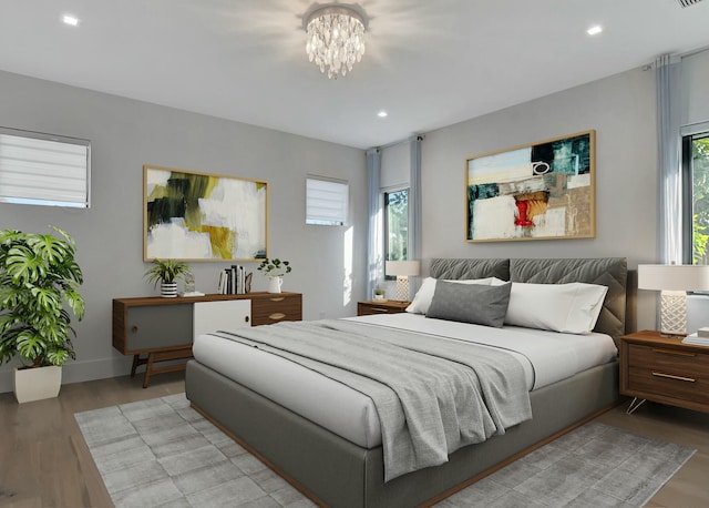 bedroom with light hardwood / wood-style flooring and a chandelier