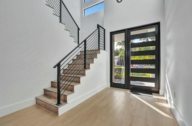 unfurnished bedroom with multiple windows, access to exterior, a chandelier, and light hardwood / wood-style flooring