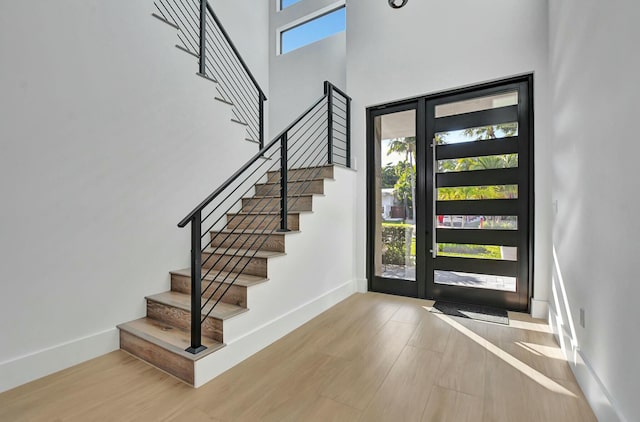 foyer entrance featuring a high ceiling and light hardwood / wood-style floors