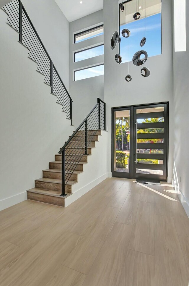 unfurnished bedroom with a notable chandelier, wood-type flooring, and a barn door