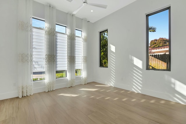 empty room with ceiling fan, light hardwood / wood-style flooring, and a wealth of natural light