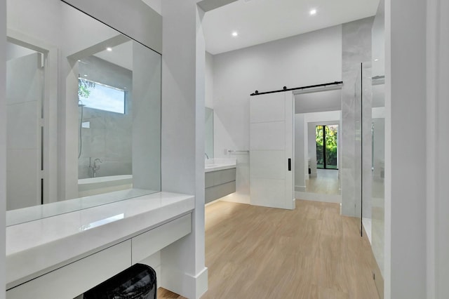 bathroom featuring a shower, vanity, wood-type flooring, and plenty of natural light