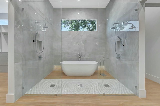 bathroom featuring tile walls, hardwood / wood-style flooring, and shower with separate bathtub