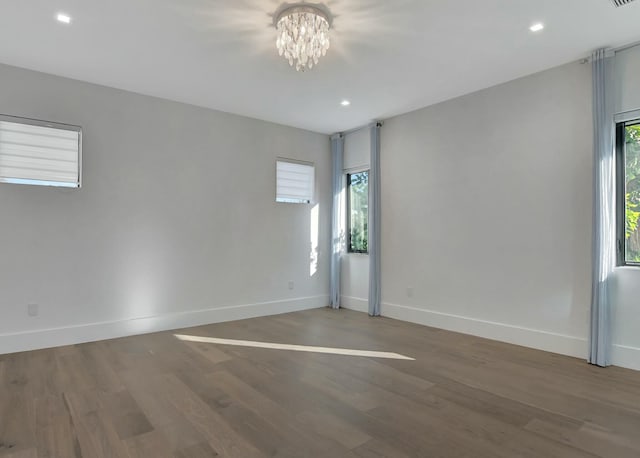 empty room featuring hardwood / wood-style floors and a notable chandelier