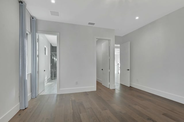 unfurnished bedroom with wood-type flooring and ensuite bathroom