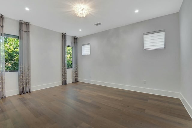 empty room with plenty of natural light and dark hardwood / wood-style floors