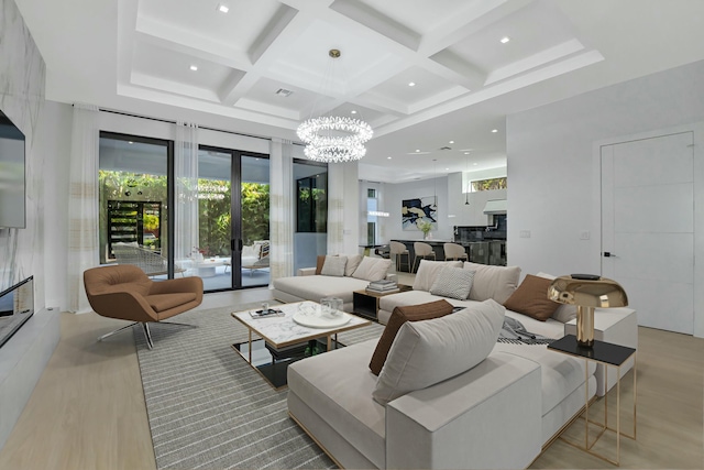 living room featuring french doors, coffered ceiling, a chandelier, beam ceiling, and light hardwood / wood-style floors