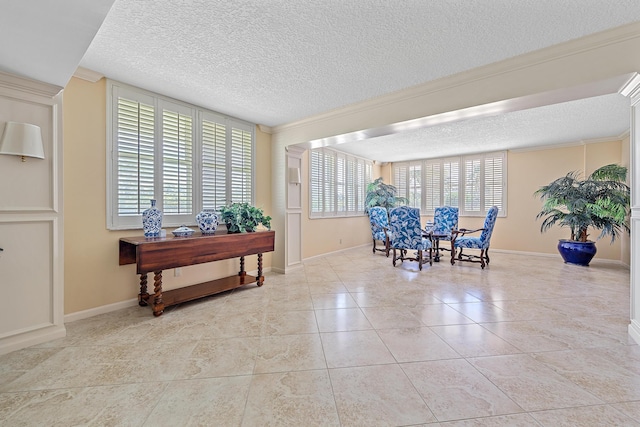 tiled dining area with ornamental molding, a wealth of natural light, and a textured ceiling